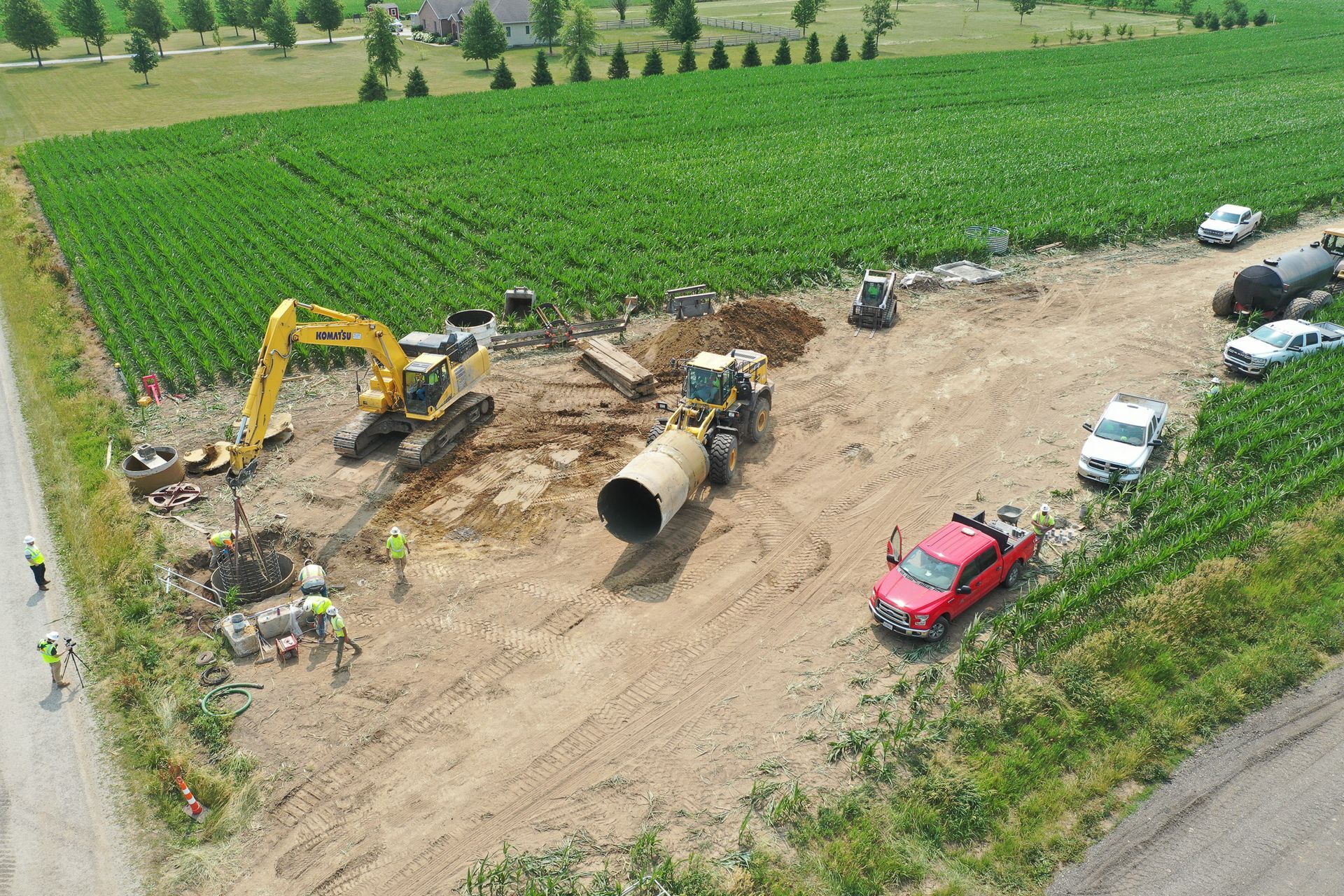 An aerial view of a construction site with a red truck parked on the side of the road.