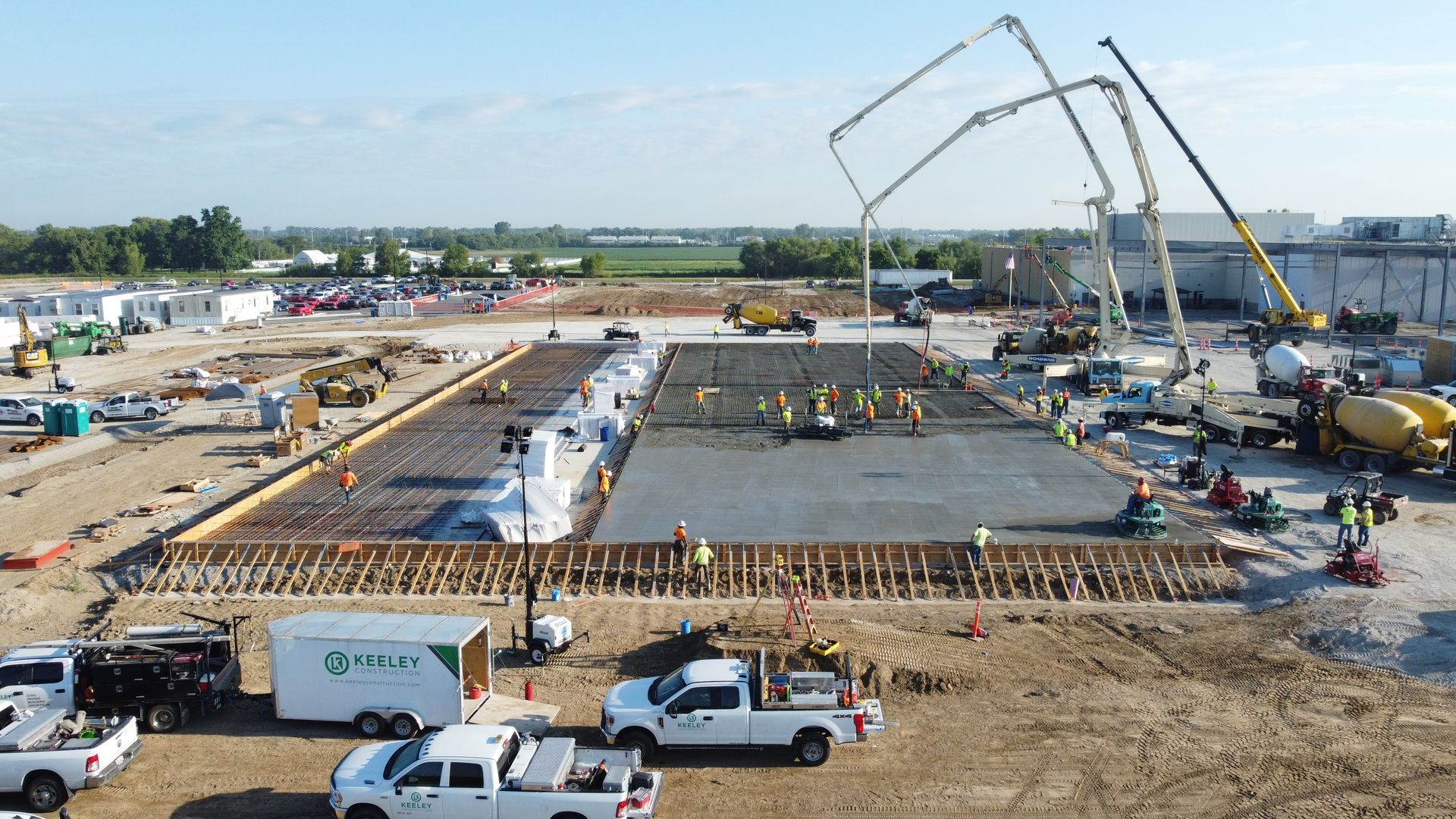 An aerial view of a construction site with trucks parked in the dirt.