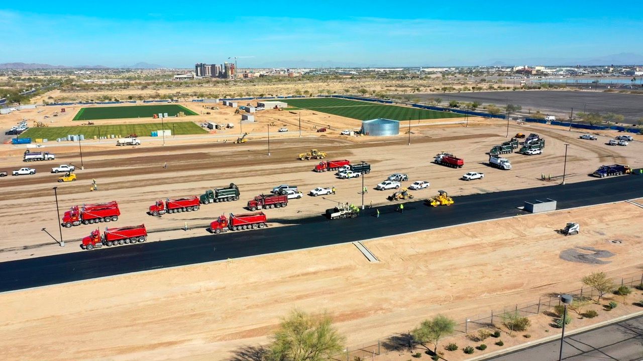 An aerial view of a construction site with trucks parked on the side of the road.