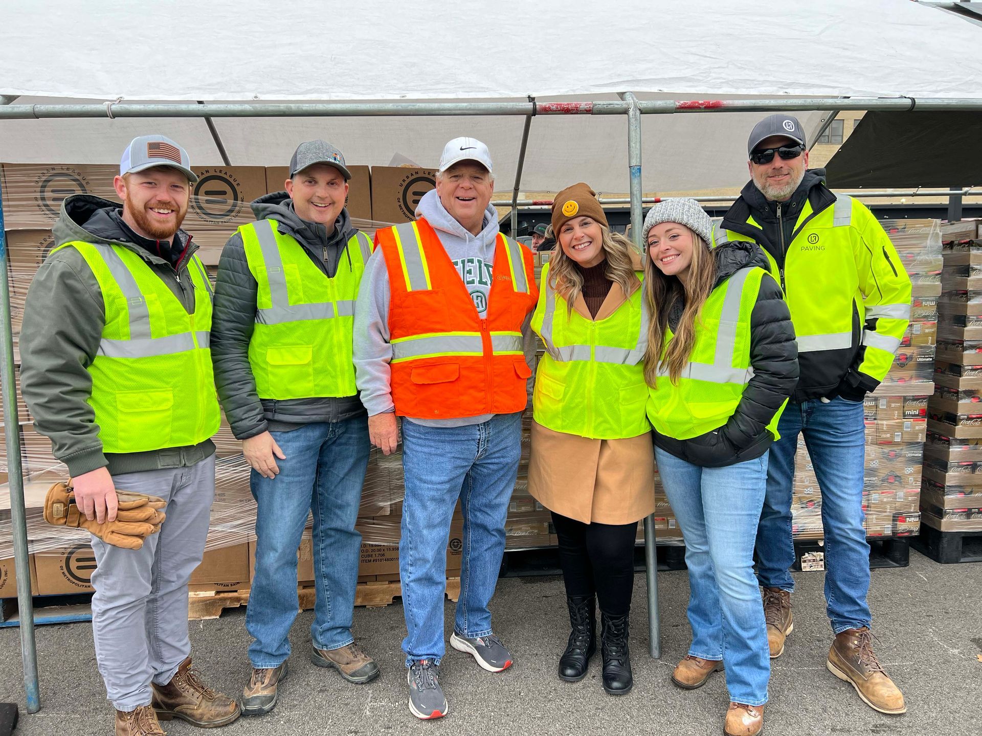 A group of people wearing safety vests are posing for a picture.
