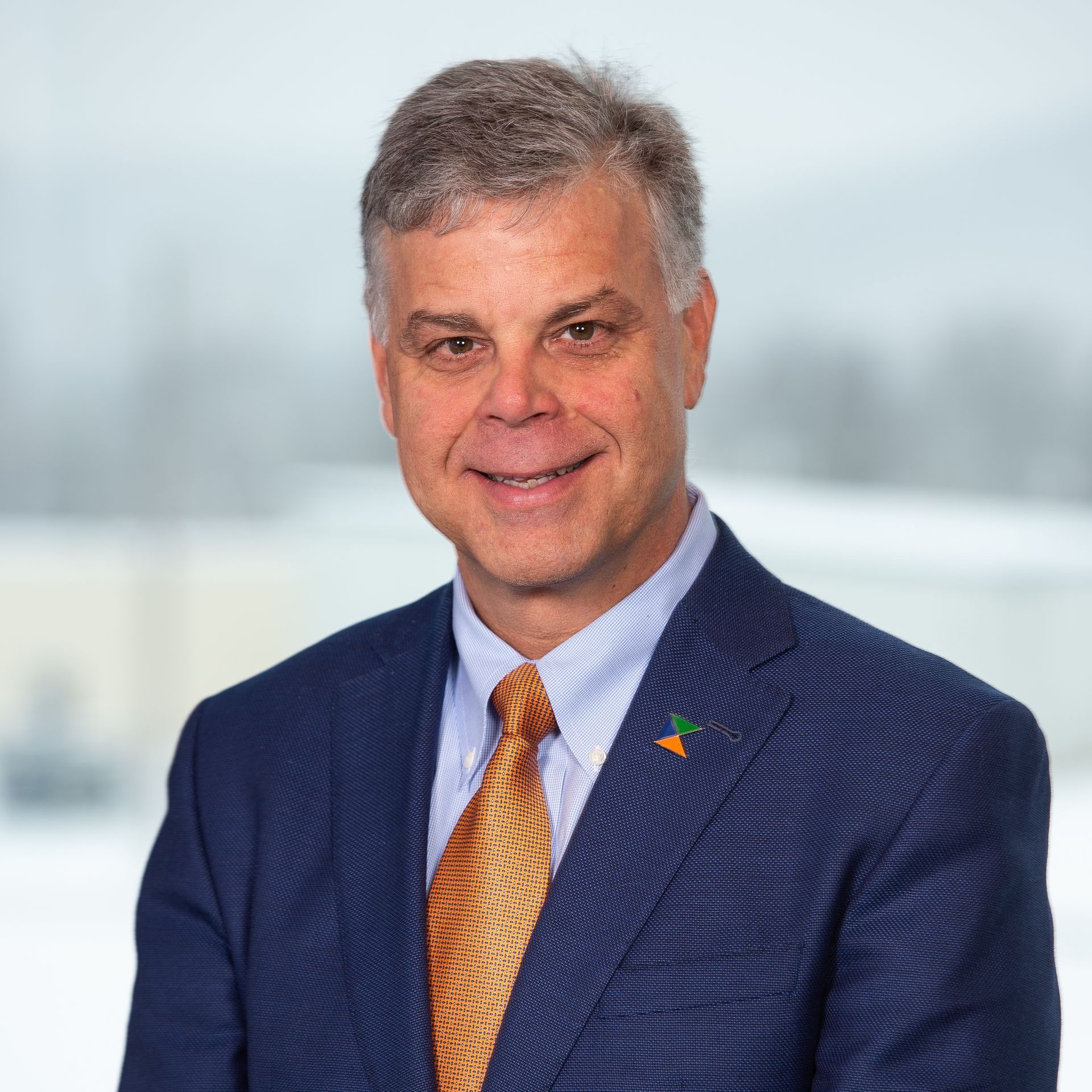 A man in a suit and tie is smiling for the camera.