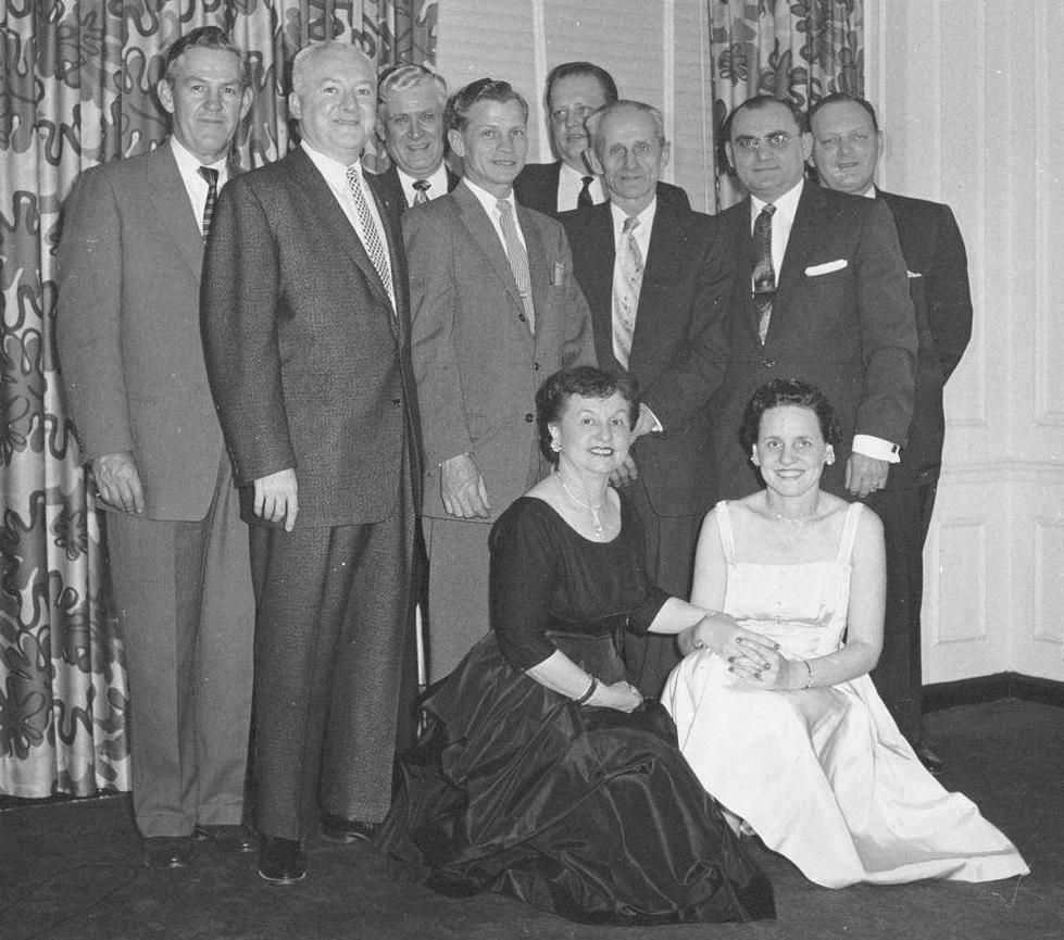 A black and white photo of a group of men and women