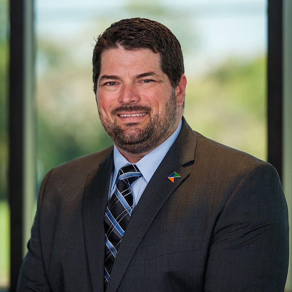 A man in a suit and tie is smiling for the camera.