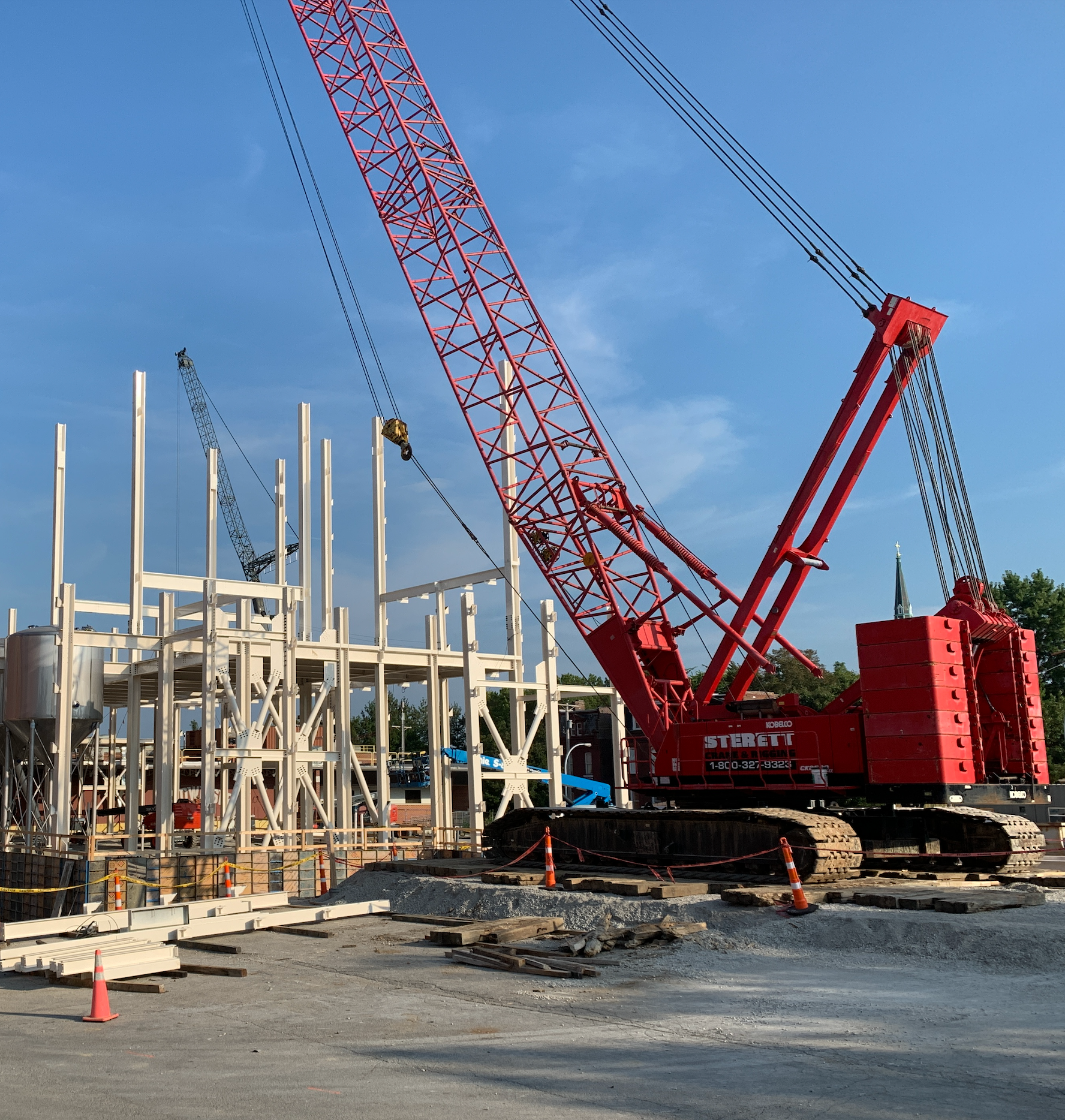 A construction site with a large red crane that says hyundai on it