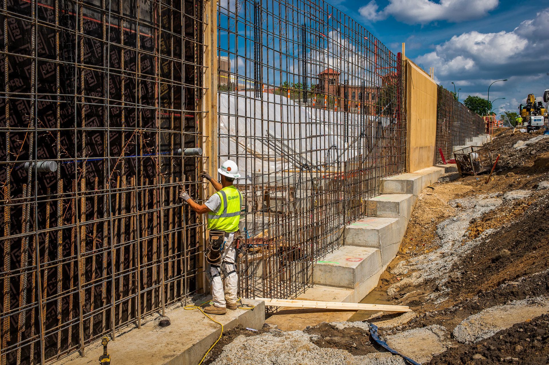 A construction worker is working on a wall at a construction site.