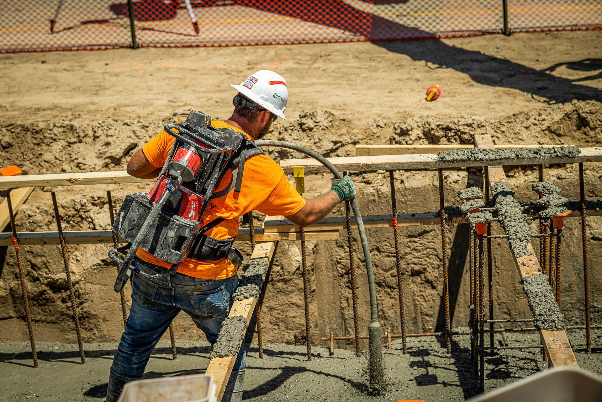 A construction worker is pumping concrete at a construction site.