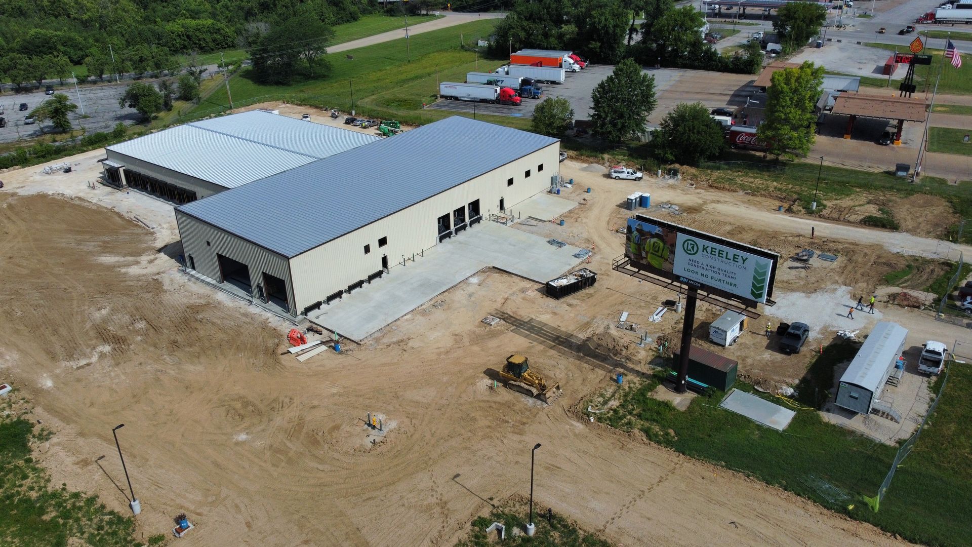 An aerial view of a building under construction in a dirt field.