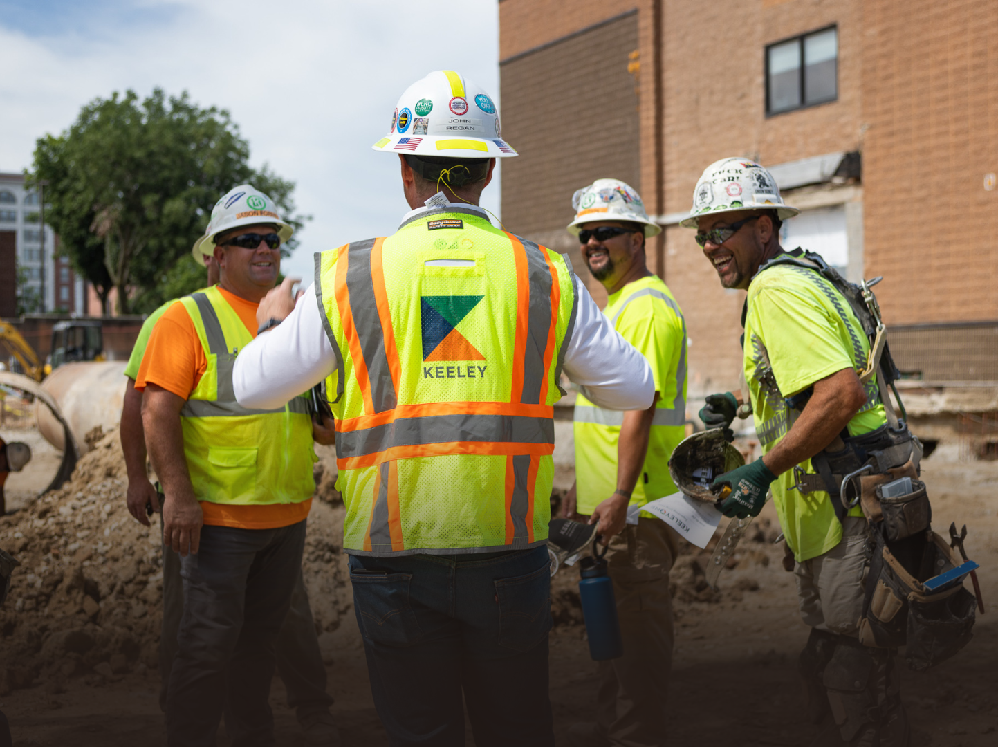 A group of construction workers are standing next to each other on a construction site.