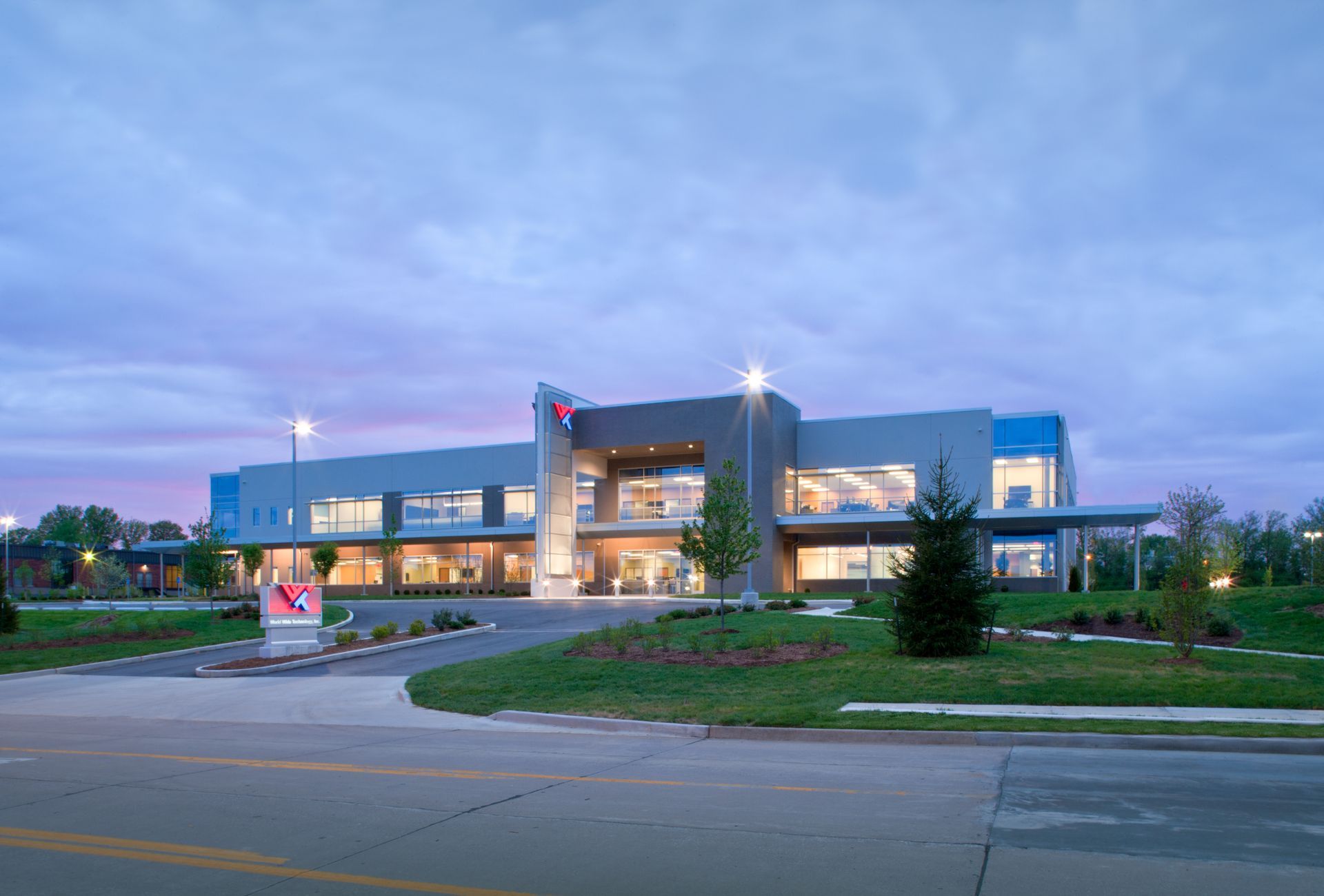 A large building with a lot of windows is lit up at night.