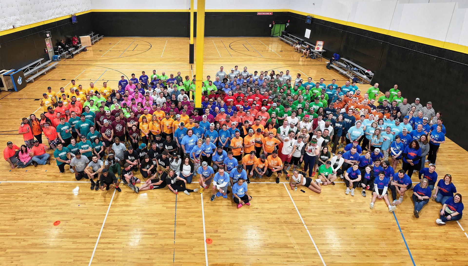 A large group of people are posing for a picture in a gym.