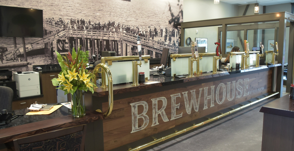 A brewhouse counter with a vase of flowers on it