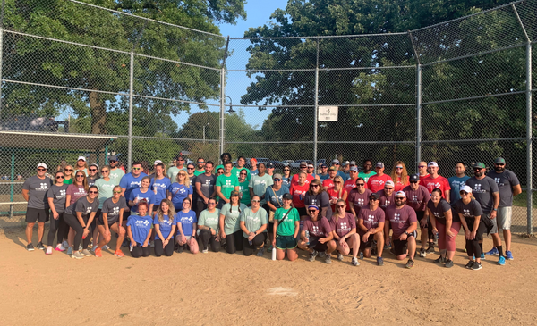 A large group of people are posing for a picture on a baseball field.