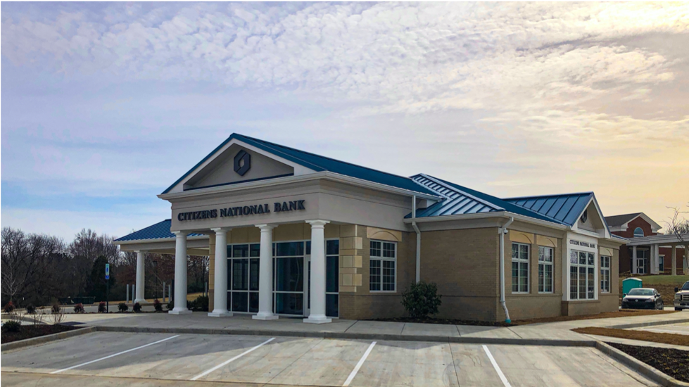 A bank building with a blue roof and white columns