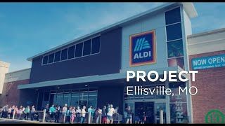 A group of people are standing outside of an aldi store.