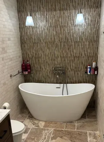 A bathroom with a bathtub , toilet and shower.