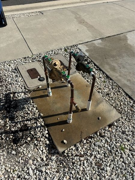 A bunch of pipes are sitting on a concrete surface