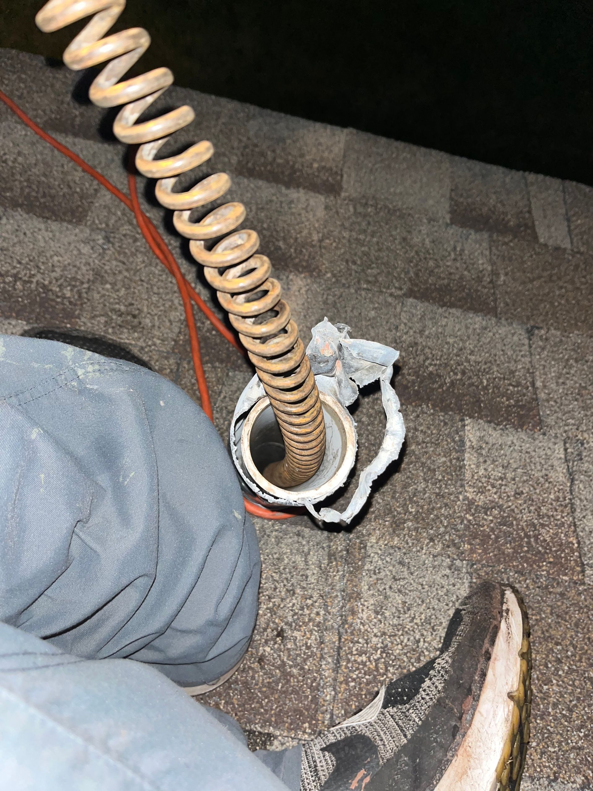 A person is using a hose with a spring attached to it