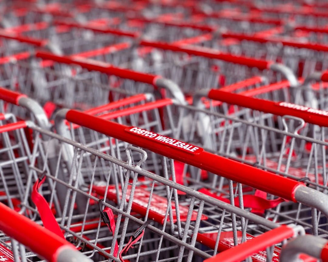 Rows of red-handled shopping carts stacked together, likely outside a store.