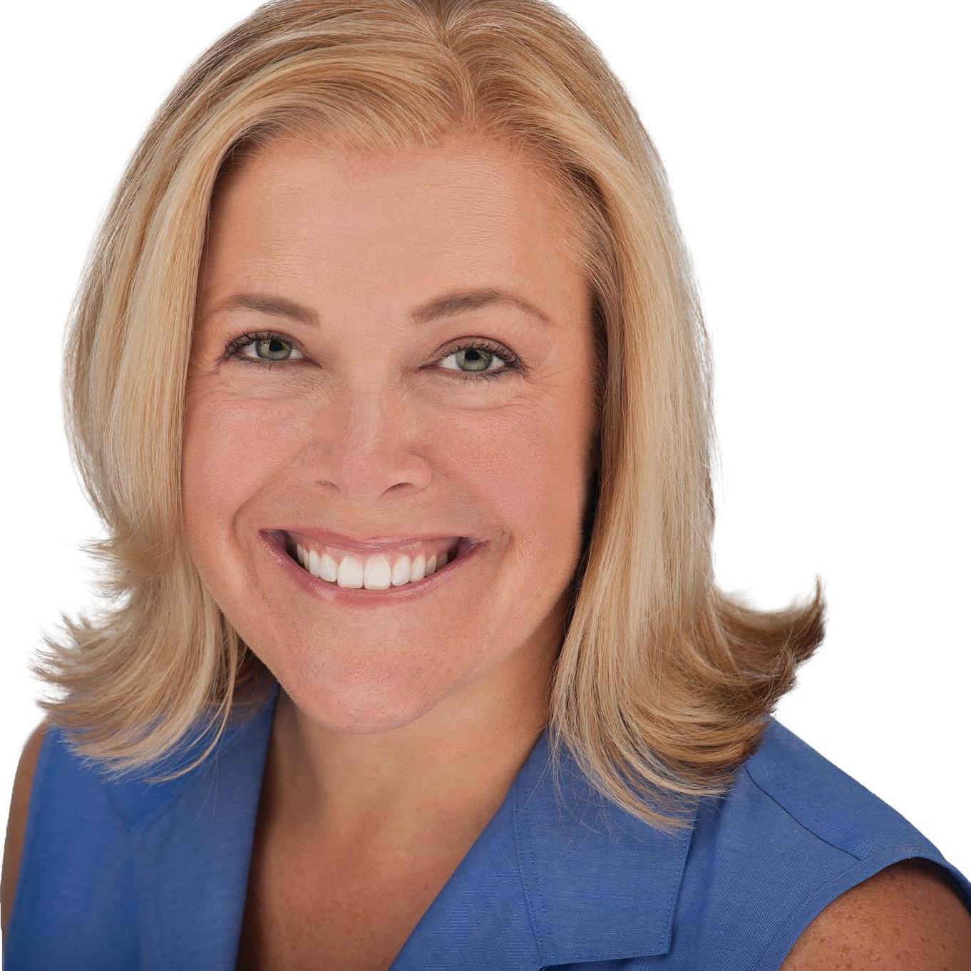 A woman in a blue shirt is smiling for the camera