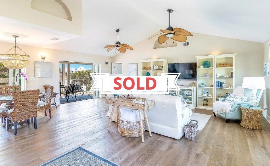 A living room with a sold sign on the wall.