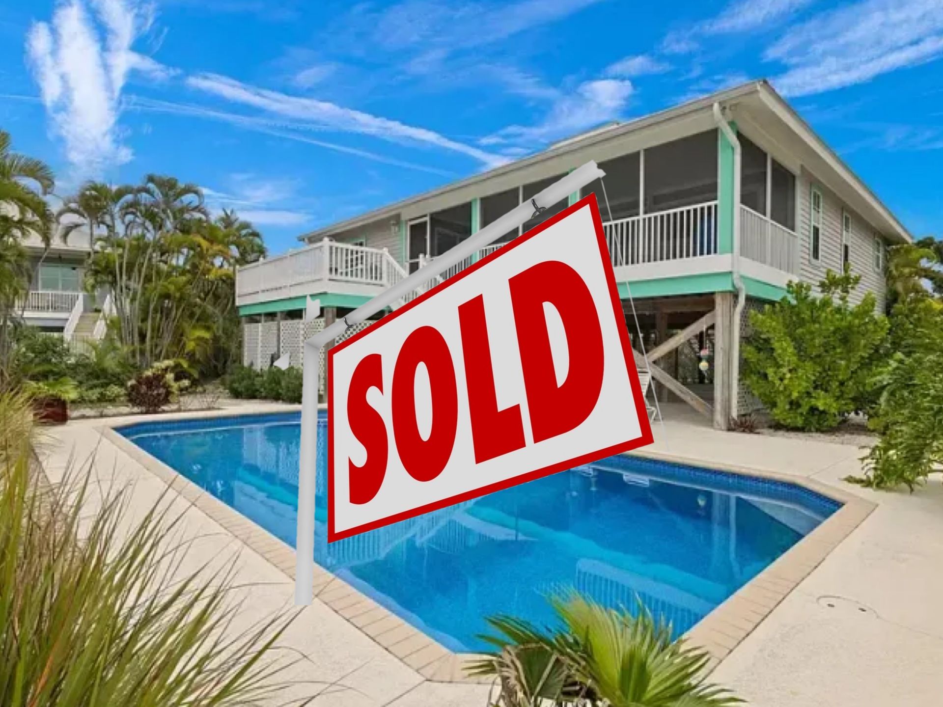 A house with a swimming pool and a sold sign in front of it.