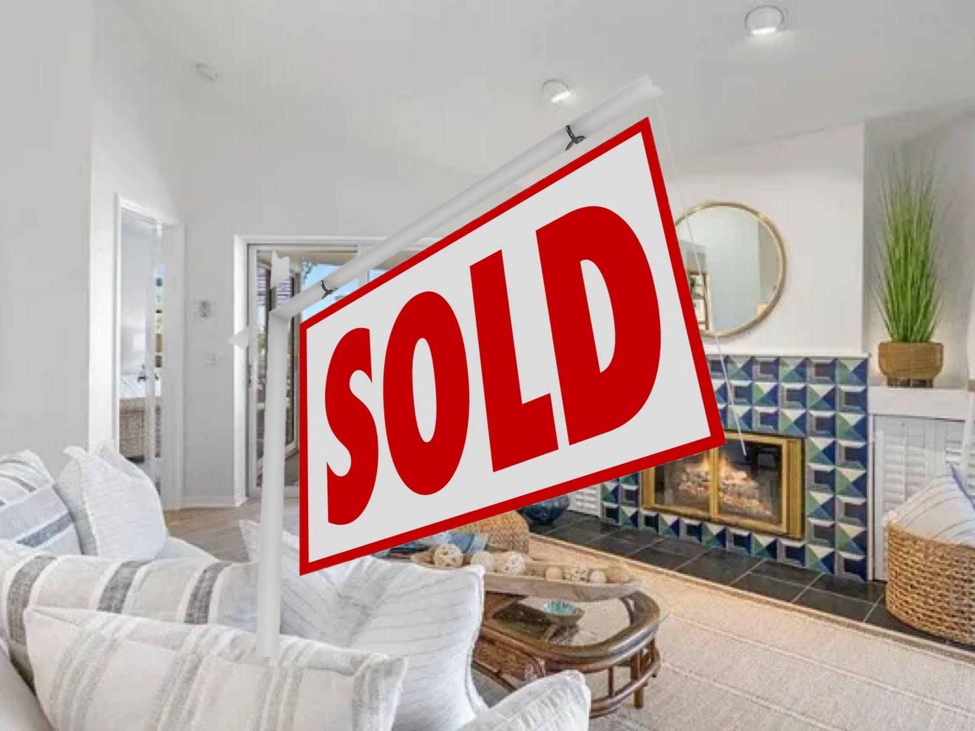 A living room with a sold sign in the foreground.