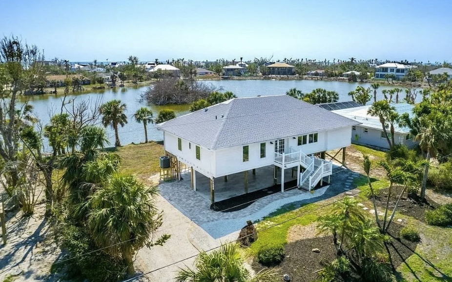 An aerial view of a house on stilts next to a body of water.