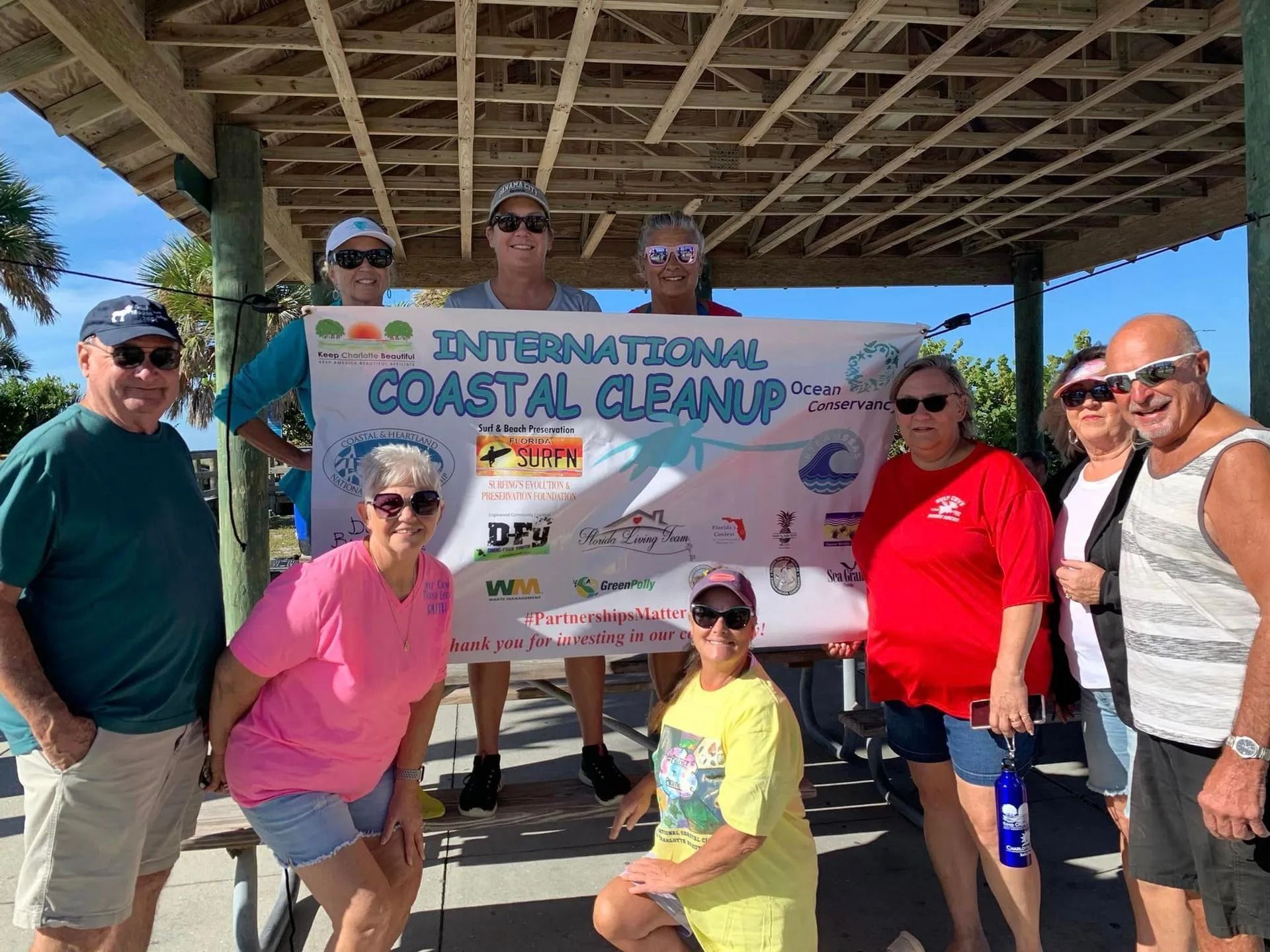 A group of people standing in front of a sign that says international coastal cleanup.