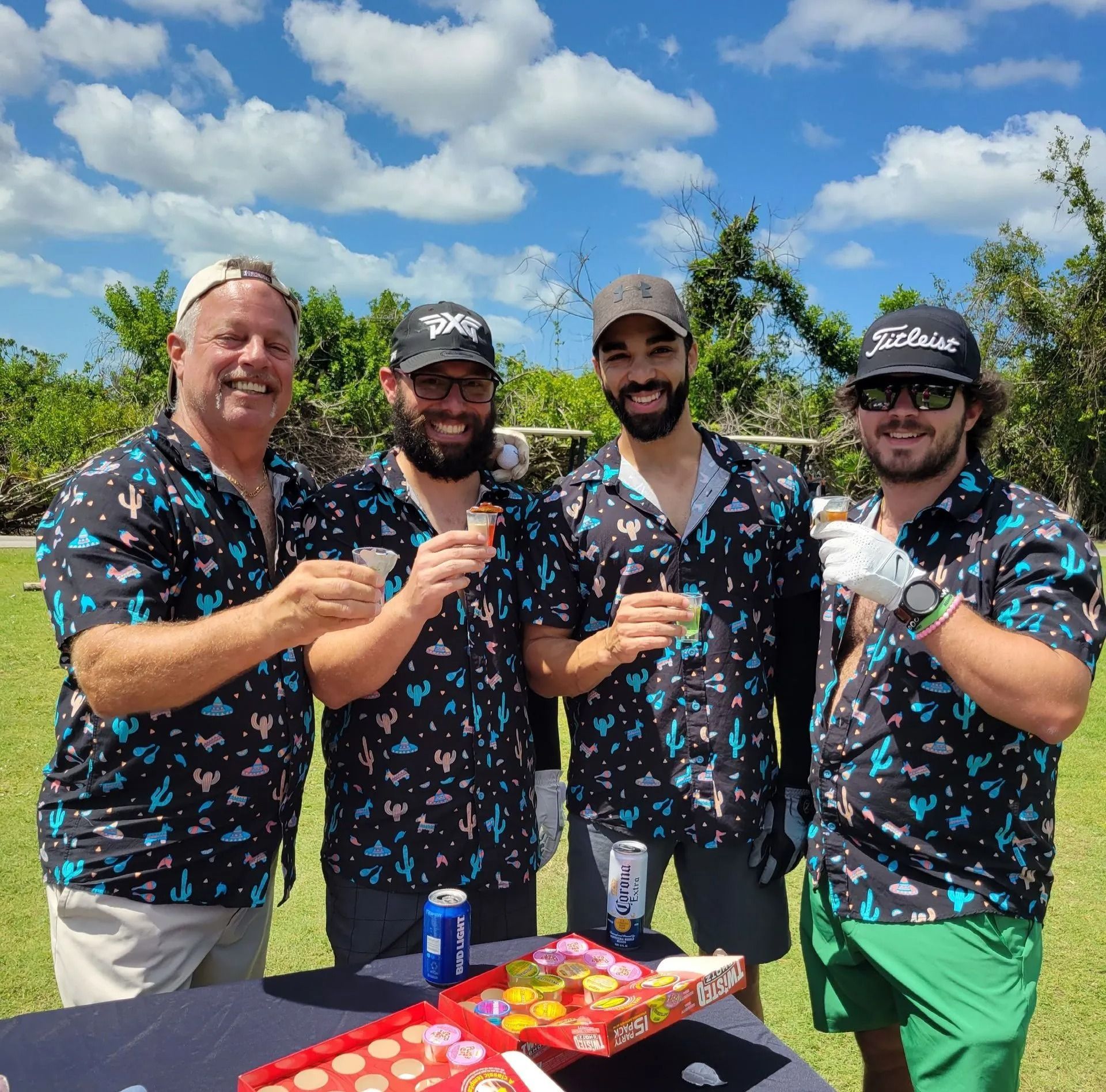 A group of men are standing around a table holding drinks