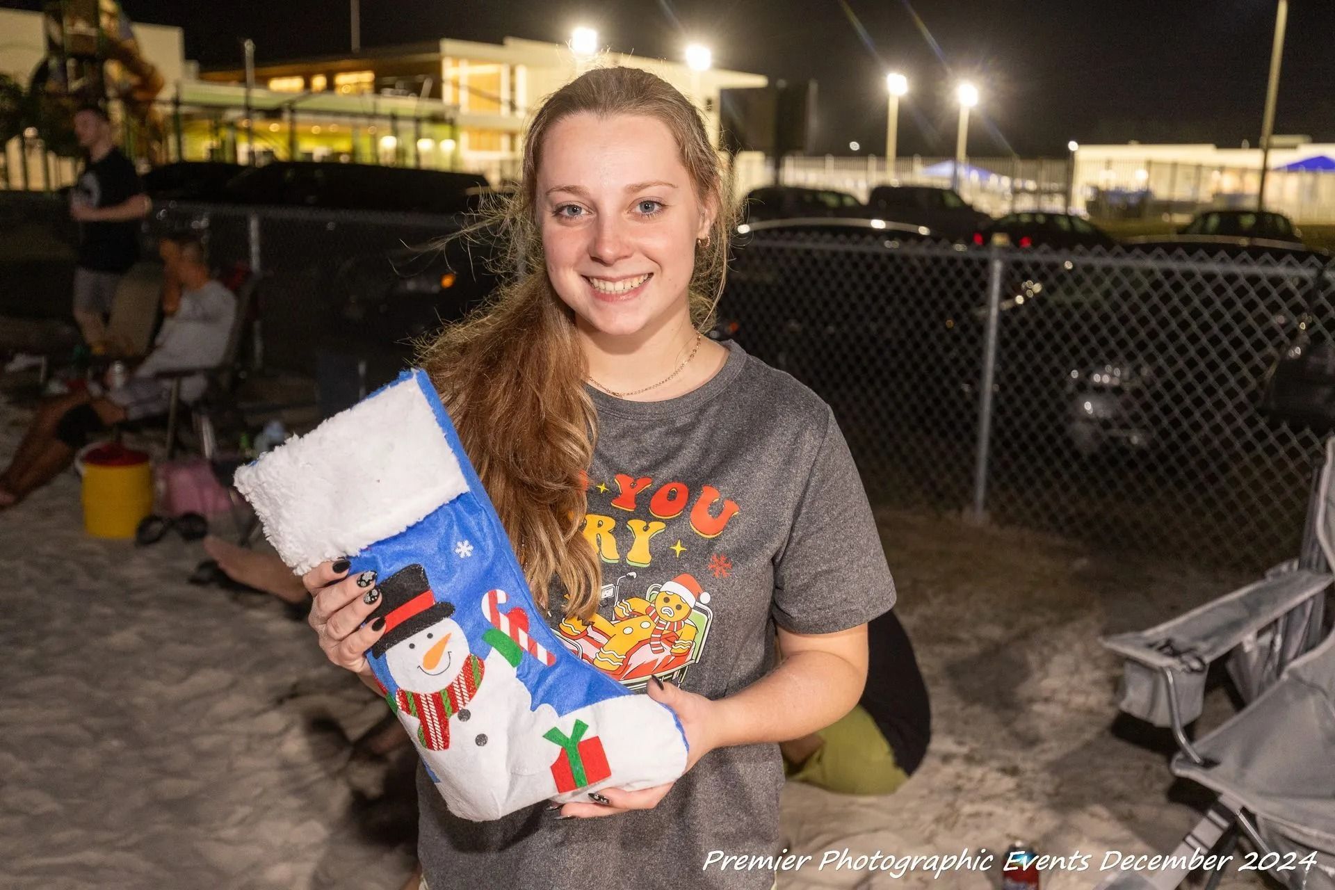 A woman is holding a christmas stocking with a snowman on it.