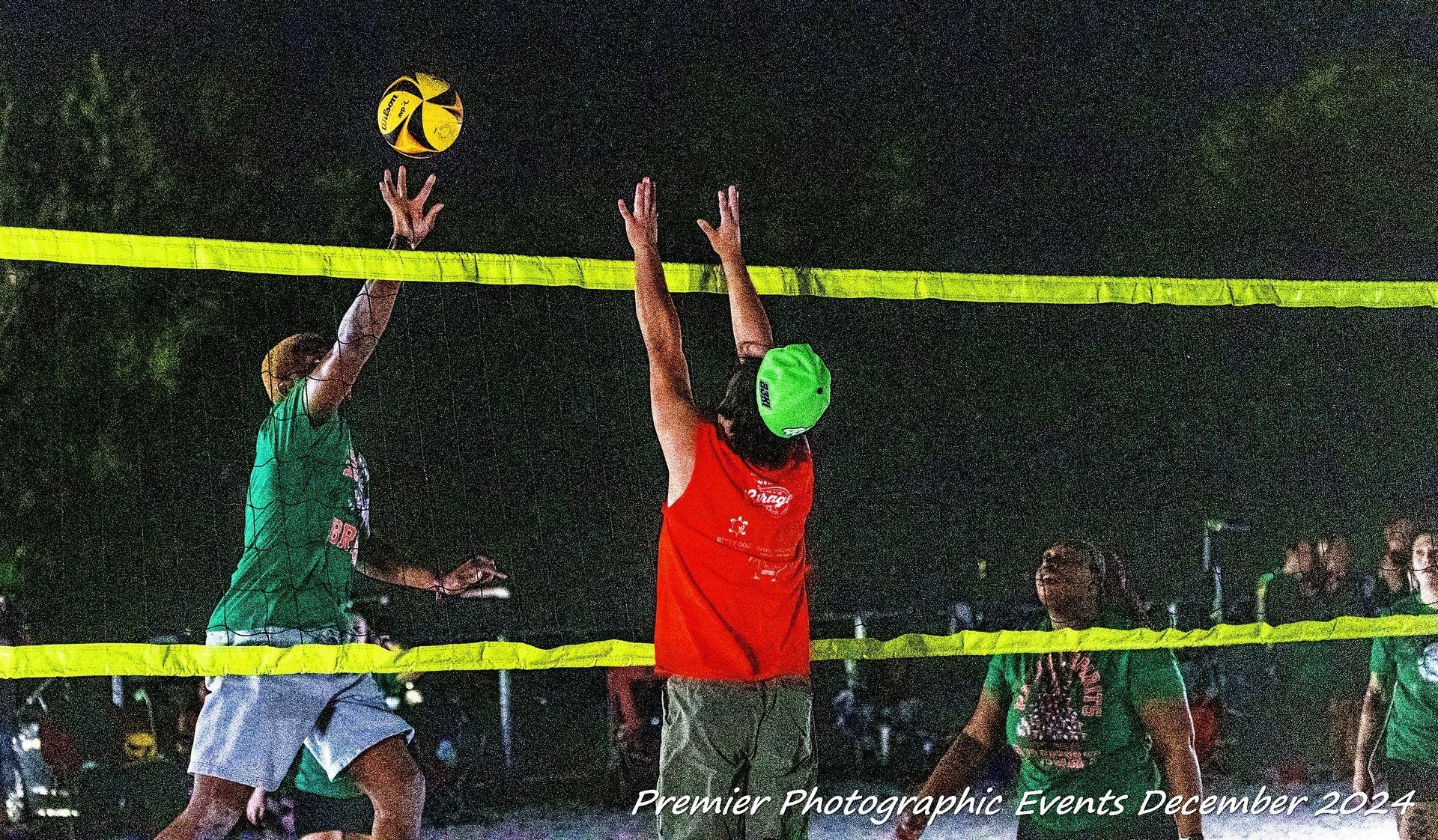 A group of people are playing volleyball in the rain.
