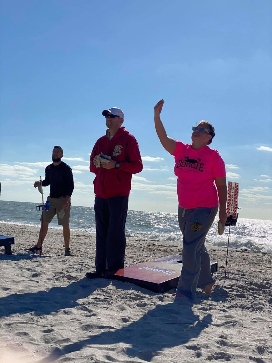 A group of people are playing a game on the beach.