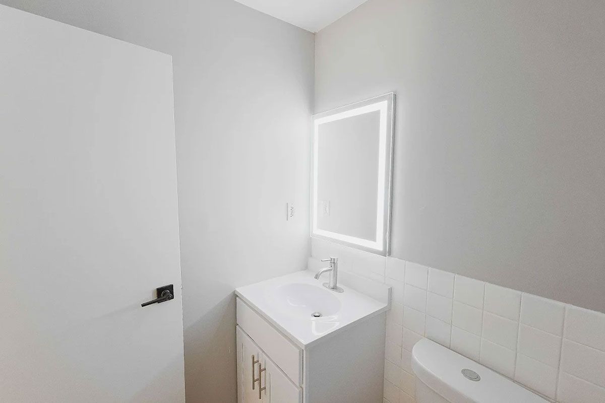 A bathroom with a sink , mirror and toilet.