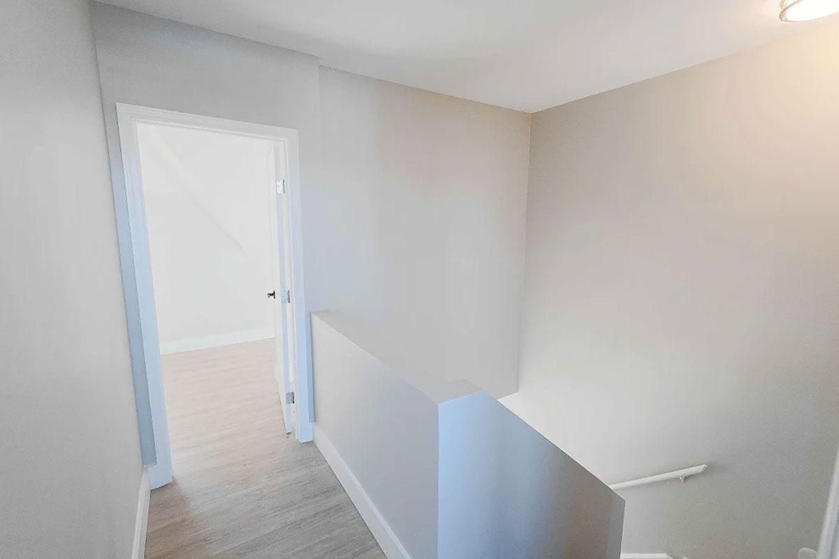 A hallway with stairs leading up to the second floor of a house.