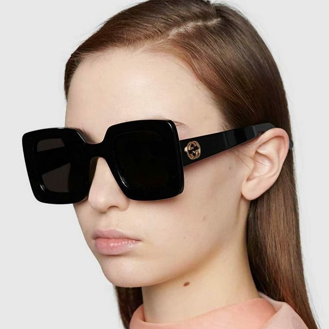 Una donna che indossa un paio di occhiali da sole quadrati neri