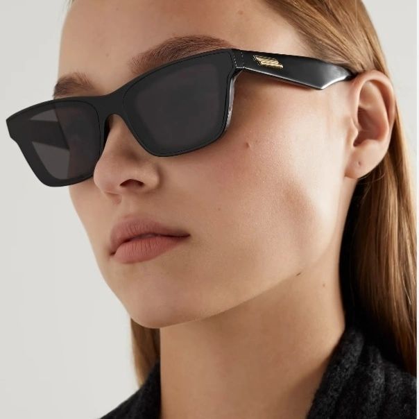 Una donna indossa un paio di occhiali da sole neri