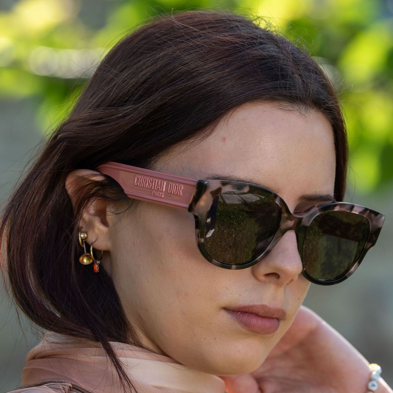 Una donna che indossa una giacca bianca e occhiali da sole neri