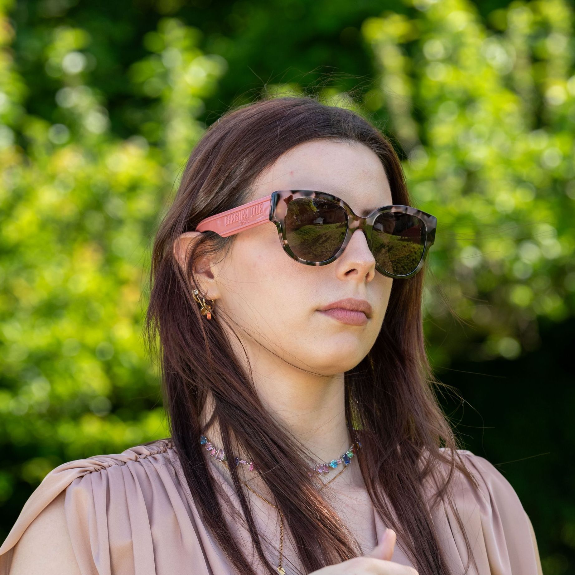 Una donna che indossa una giacca bianca e occhiali da sole neri