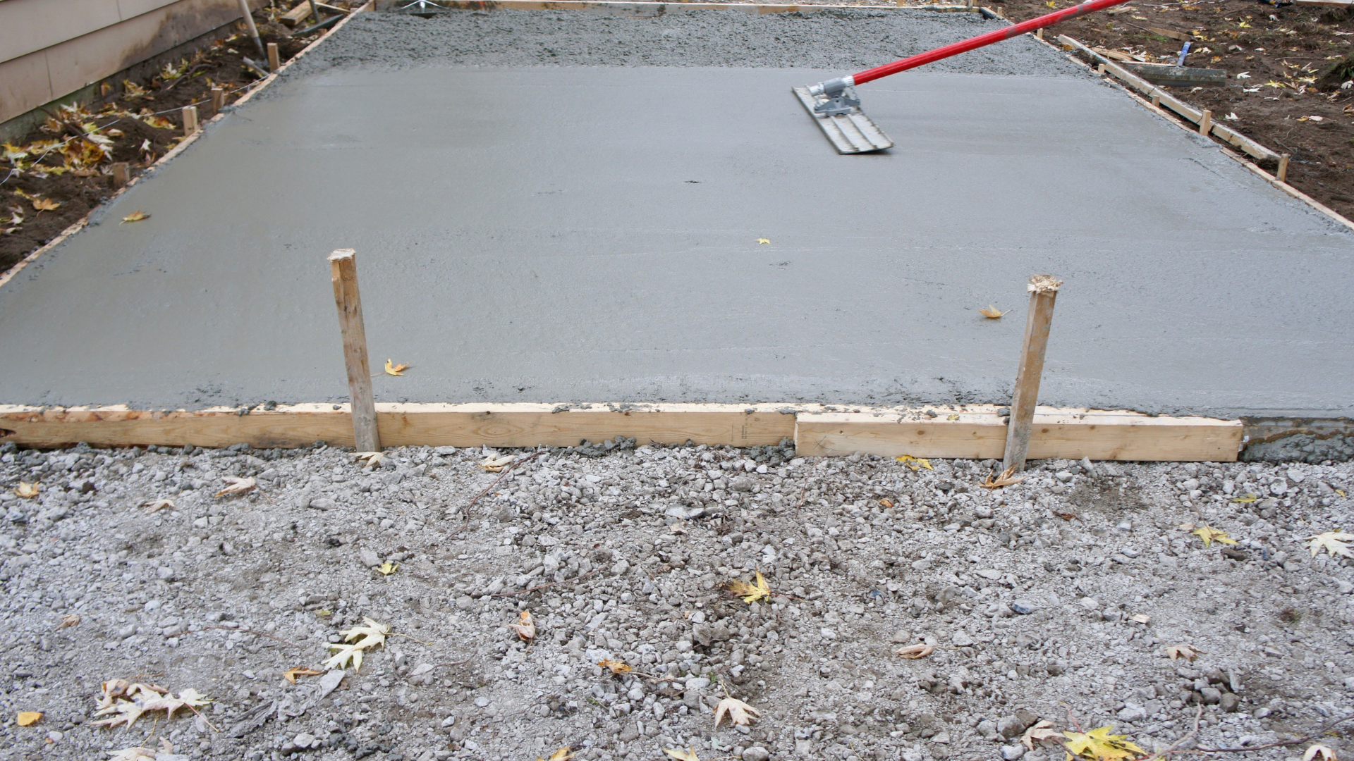 freshly poured concrete for a driveway being leveled