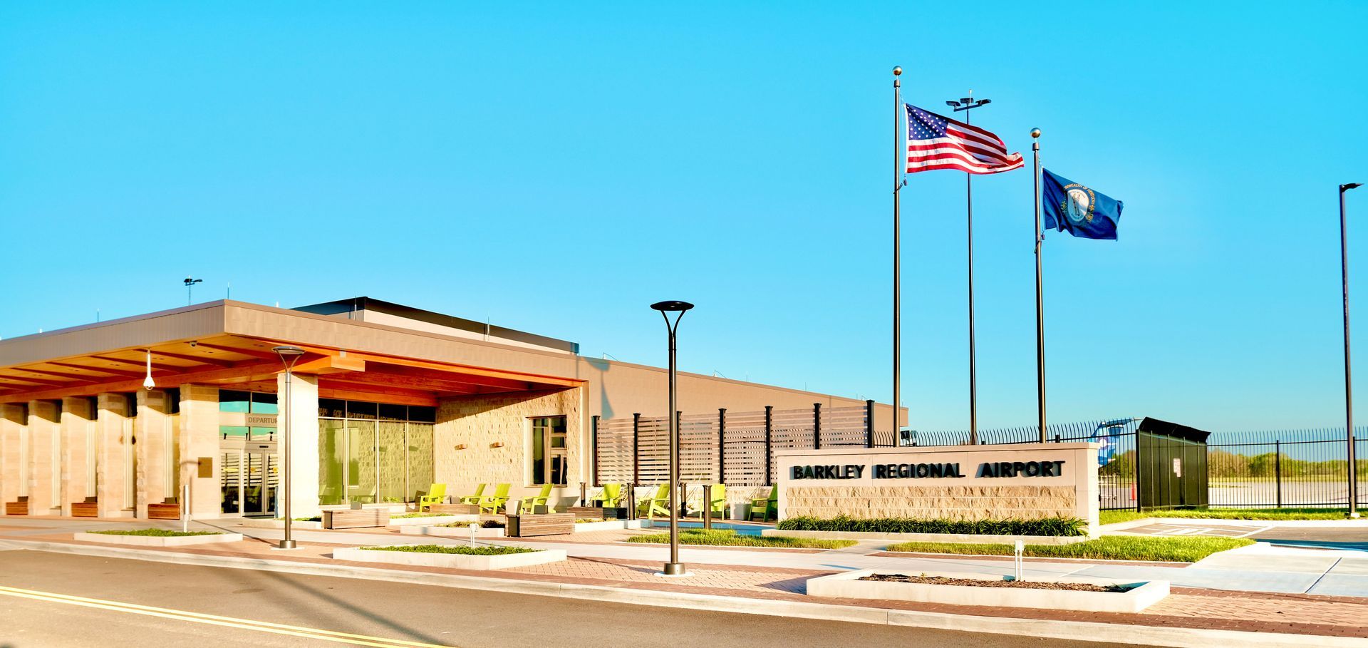 A large building with three american flags flying in front of it.