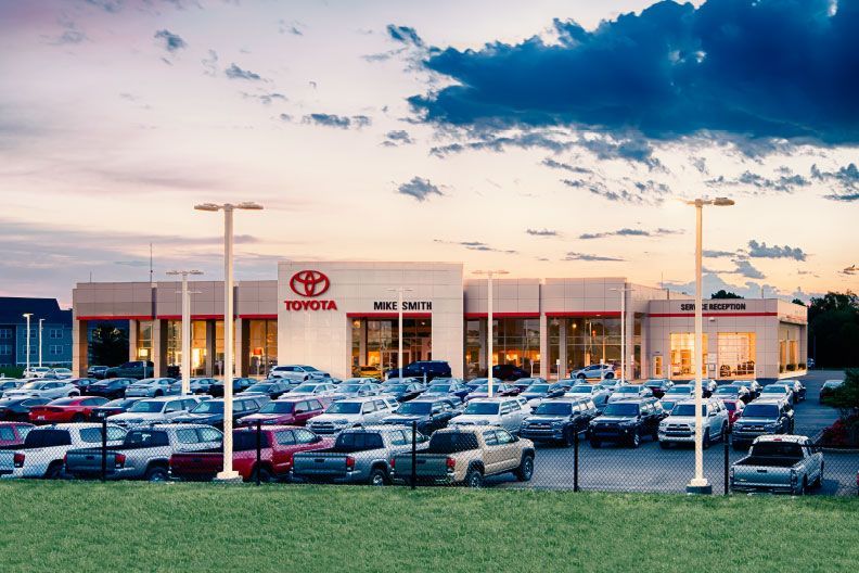 A toyota dealership with a lot of cars parked in front of it