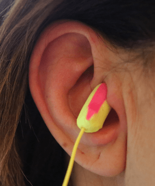 A close up of a person 's ear with ear plugs in it