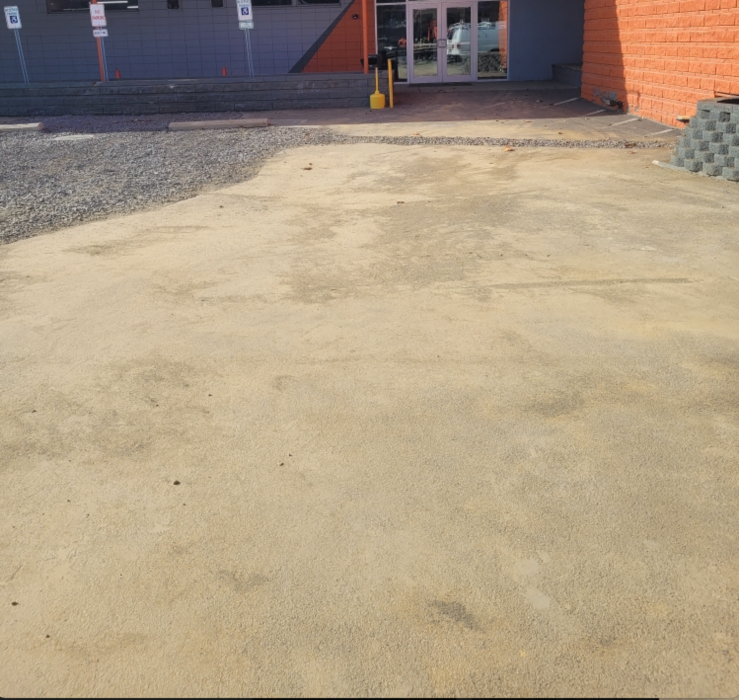 A brick building with a parking lot in front of it