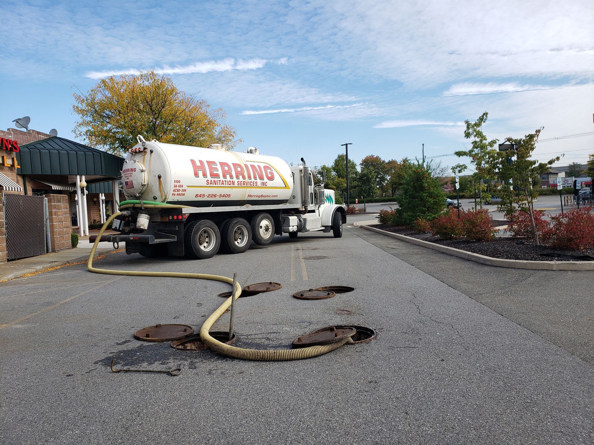 A white truck with the word herring on the side is parked in a parking lot.
