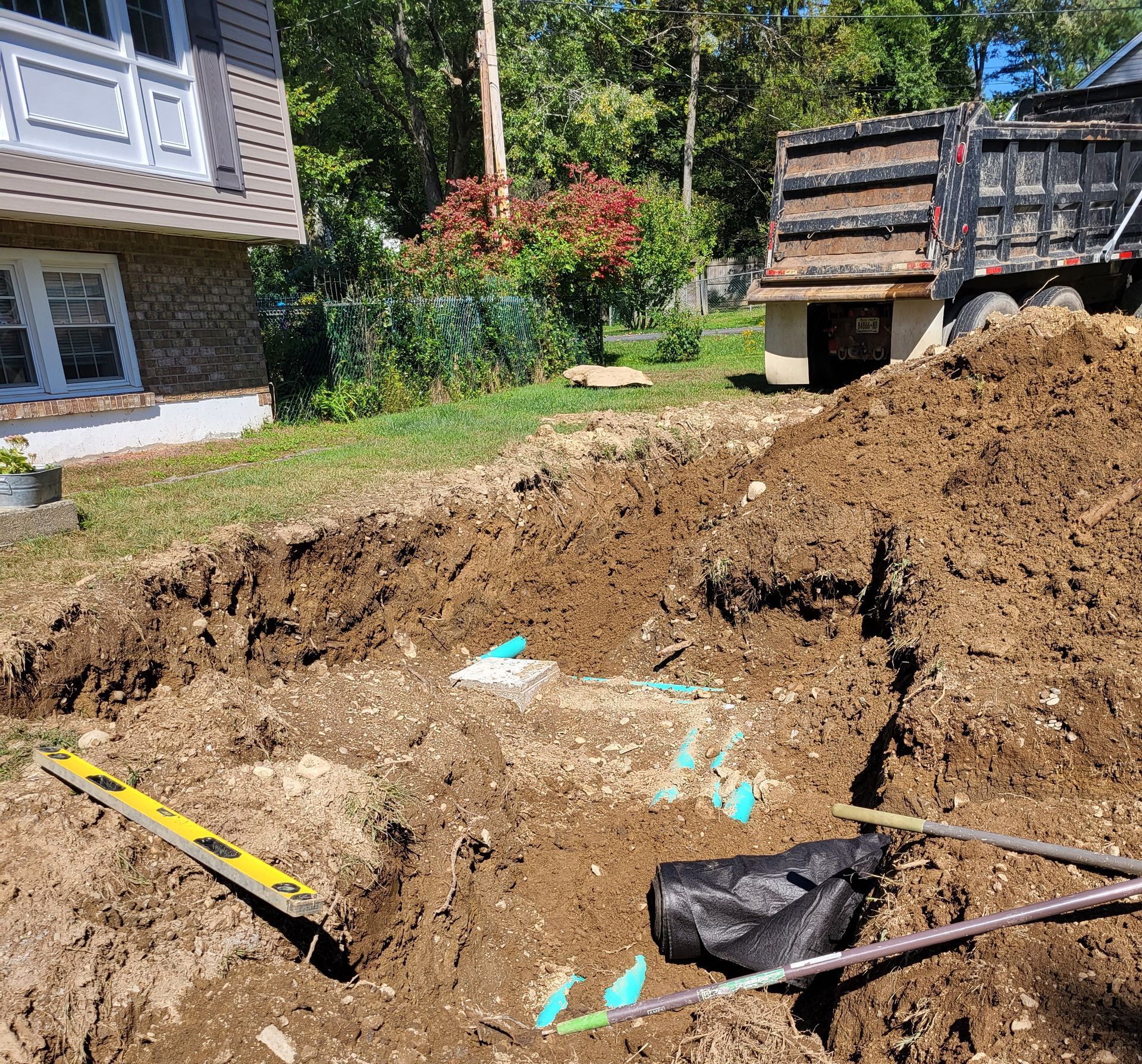A large pile of dirt is sitting in front of a house.