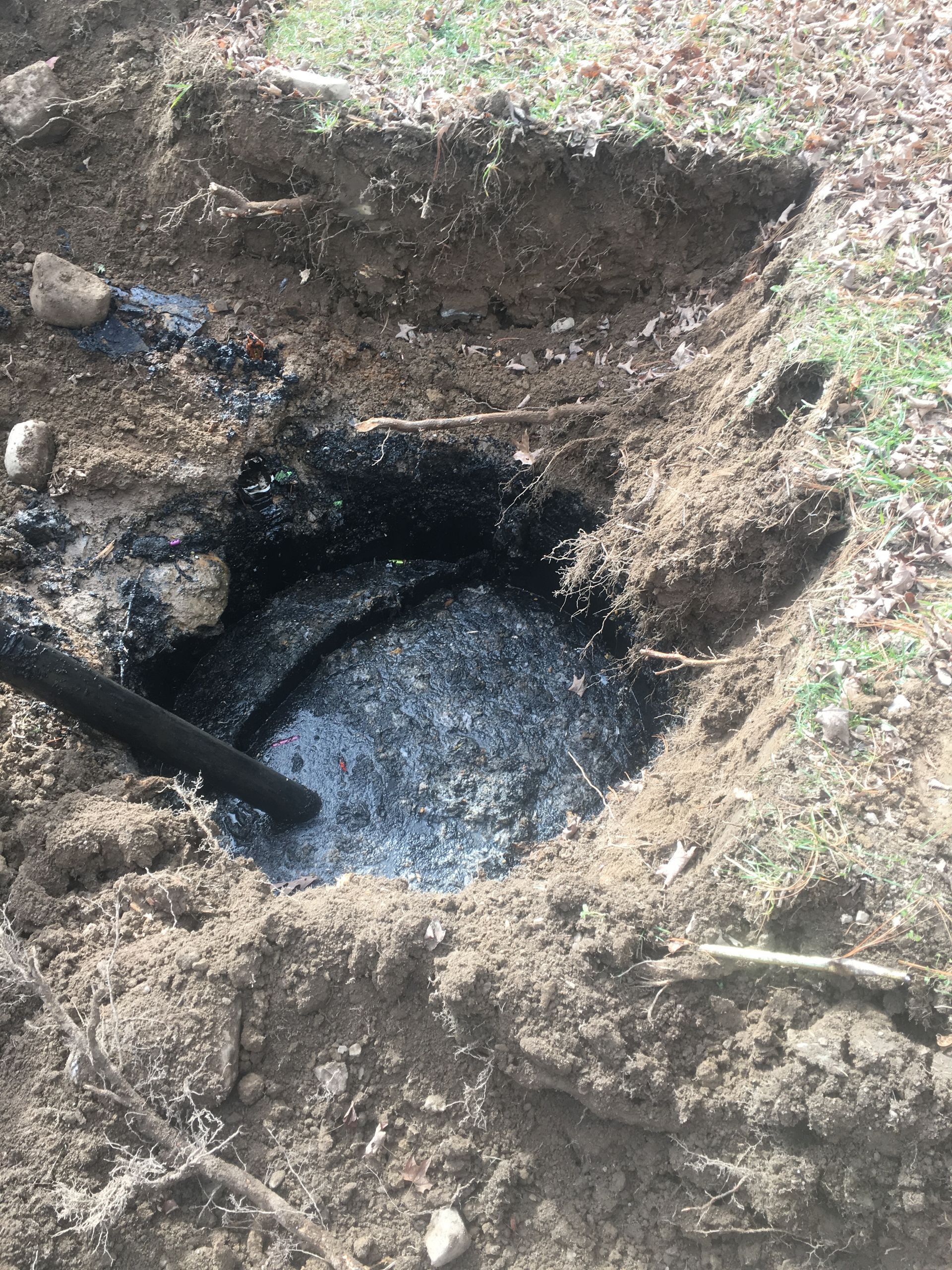 A hole in the ground with water coming out of it.