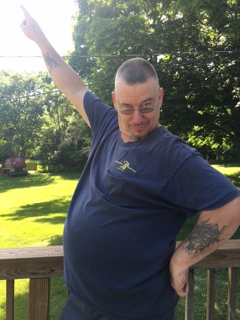 A man with a tattoo on his arm is pointing up