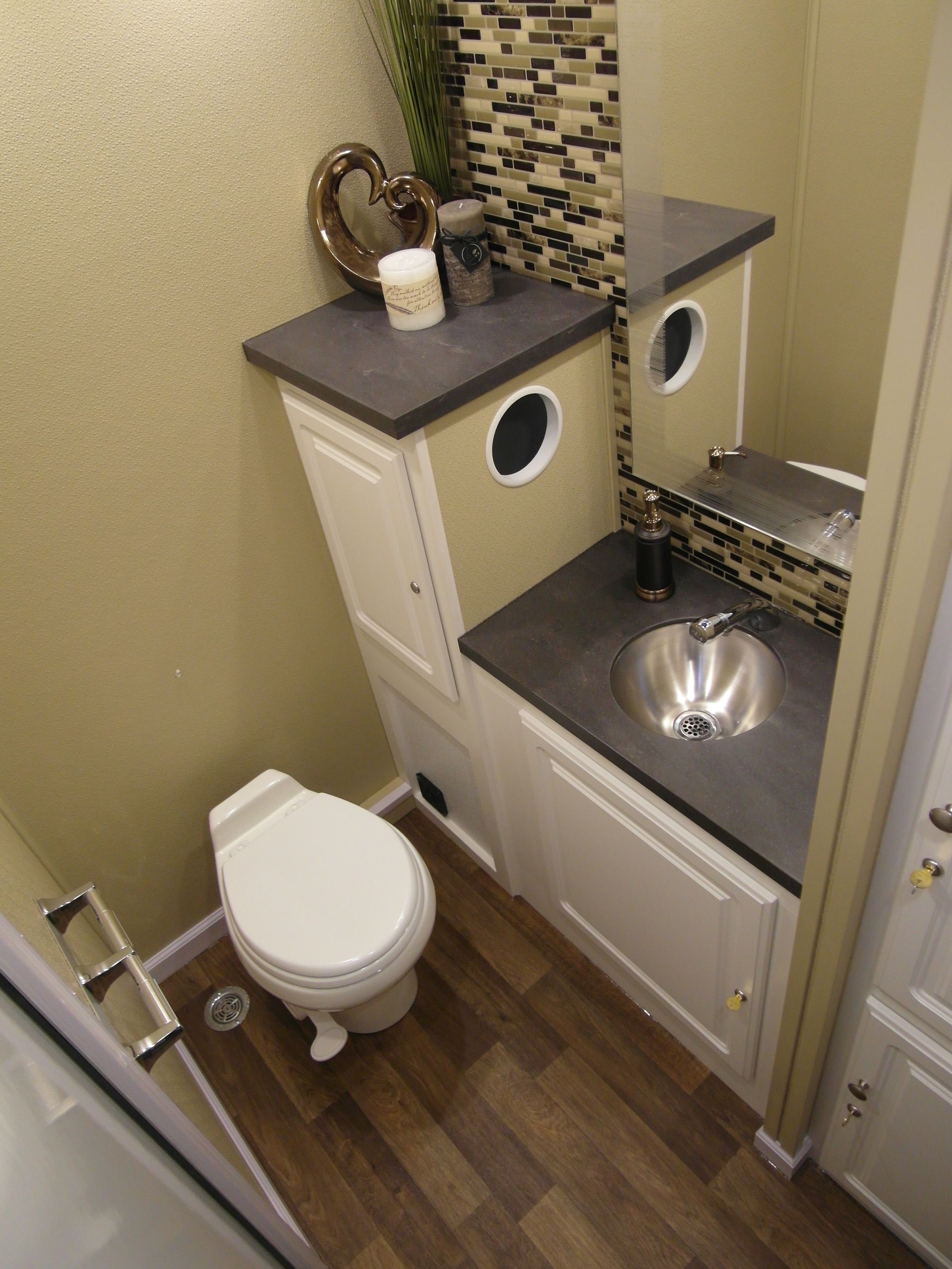 A bathroom with a toilet a sink and a mirror