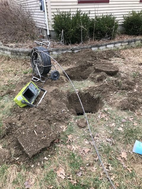 A camera is sitting on top of a pile of dirt in front of a house.