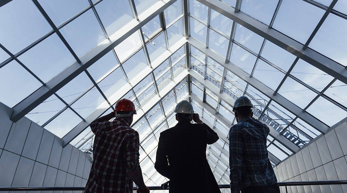 3 architects in front of glass roof — Machinery window replacements Gladstone in Tannum Sands, QLD